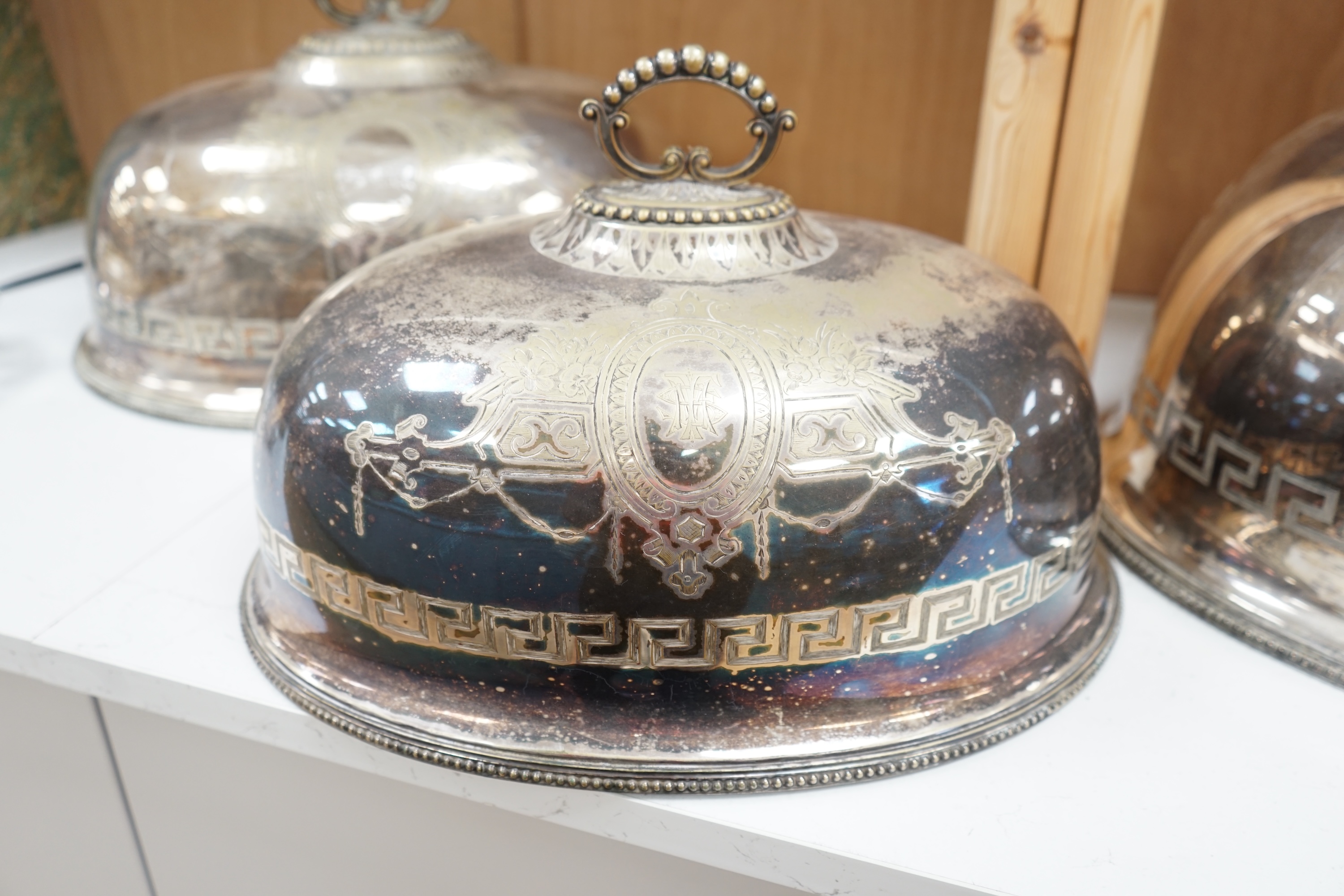 A set of three graduated Victorian silver plated meat dish covers, 51cm wide. Condition - plate in places worn